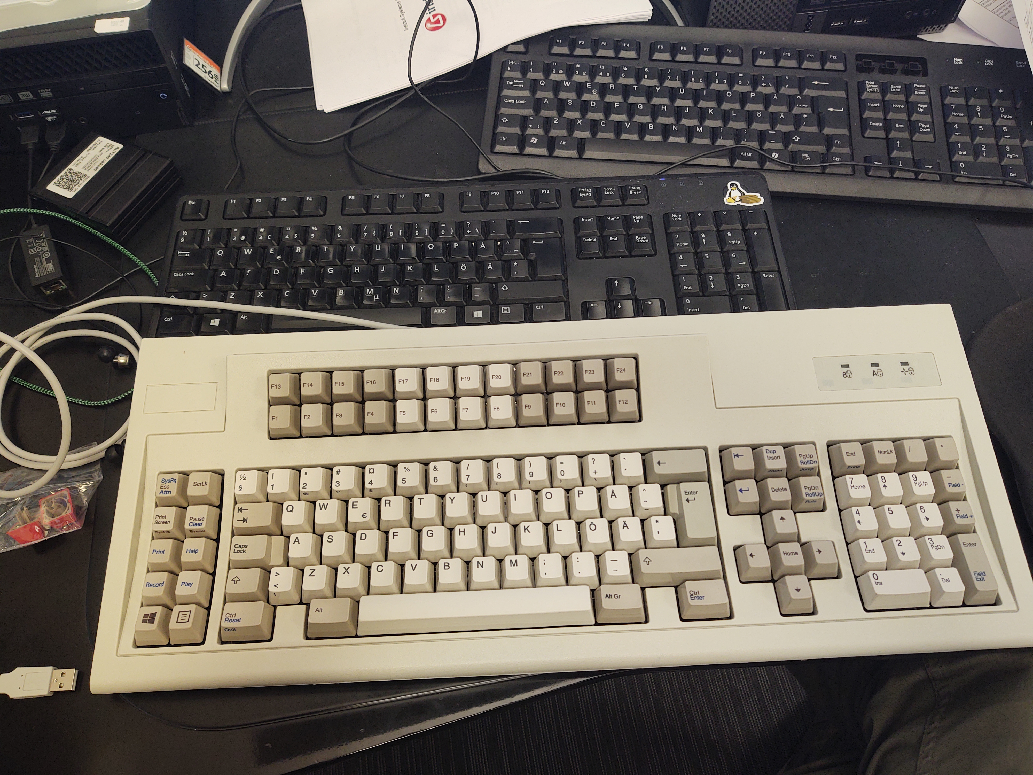 Keyboard on desk with two other crappy ones